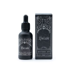 Frasco de aceite de perfume Hécate de 30 ml con cuentagotas junto a su caja negra con ilustración plateada