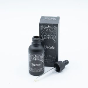 Frasco de aceite de perfume Hécate de 30 ml con cuentagotas junto a su caja negra con ilustración plateada