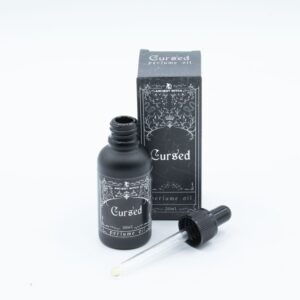 Frasco negro mate de aceite de perfume Maldito de 30 ml con cuentagotas junto a su caja negra ilustrada