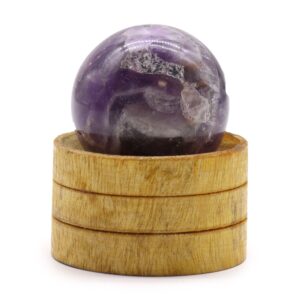 Esfera de amatista africana con zonas violetas y claras sobre un soporte de madera