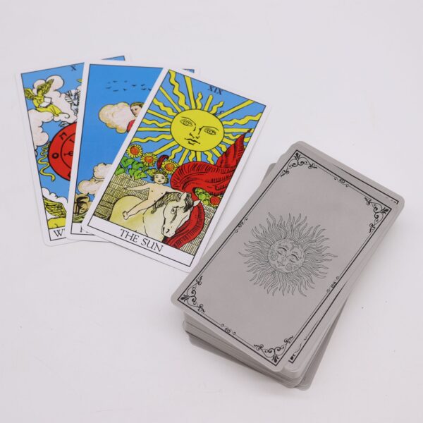 Cartas de tarot clásicas a color, El Sol y la Rueda de la Fortuna, junto al mazo con reverso gris plata