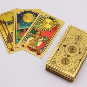 Cartas de tarot doradas El Sol, La Luna y el cuatro de bastos junto al mazo con el reverso dorado