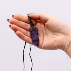 Colgante de amatista violeta en punta plana envuelta en una red de cordón negro anudado
