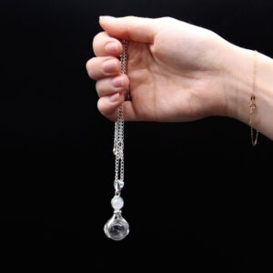 Colgante de manos con baño de plata que sostienen una esfera de cristal de roca, con cadena