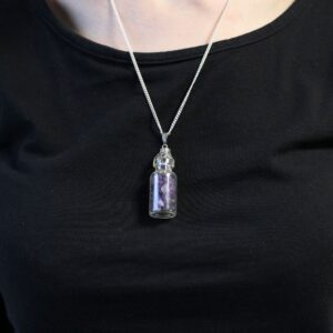 Collar con botellita de vidrio llena de lascas de amatista, remate calado y cadena con baño de plata