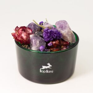 Tarro de vidrio verde con amatistas en bruto y flores secas violetas y granates