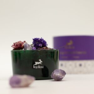 Tarro de vidrio verde con amatistas en bruto y flores secas violetas y granates