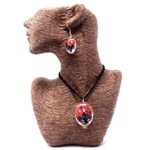 Colgante y pendientes ovalados de vidrio con un árbol de la vida de flores prensadas en rojo coral y cordón negro, en su caja