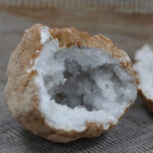 Geoda de calcita abierta en dos partes, con corteza ocre e interior de cristales blancos