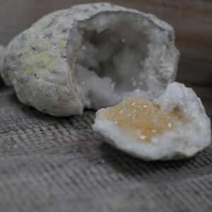 Geoda de calcita abierta en dos partes, con corteza ocre e interior de cristales blancos
