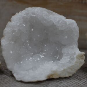 Mitad de una geoda de calcita con el interior de cristales blancos y grises