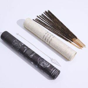 Tubo negro de incienso ritual Purificación junto a la lámina enrollada con el péndulo de cristal de roca