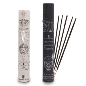 Tubo negro de incienso ritual Purificación junto a la lámina enrollada con el péndulo de cristal de roca