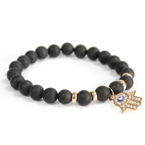 Pulsera elástica de cuentas de ágata negra mate con un charm de mano de Fátima dorado con piedrecitas y ojo azul