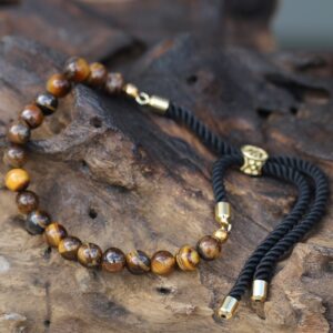Pulsera de cuentas de ojo de tigre con cordón negro trenzado y pasador deslizante en tono dorado