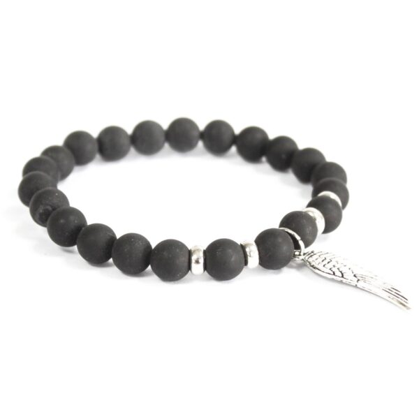 Pulsera elástica de cuentas de ágata negra con un charm de ala de tono plateado