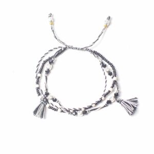 Pulsera ajustable de hilo blanco y negro con cuentas negras y plateadas y dos borlas