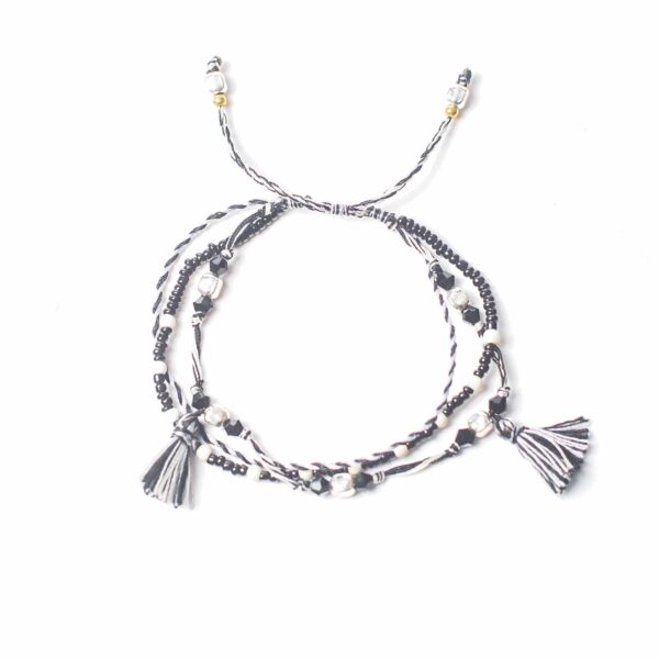 Pulsera ajustable de hilo blanco y negro con cuentas negras y plateadas y dos borlas