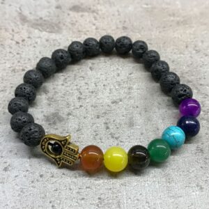 Pulsera elástica de cuentas de lava negra con una mano de Fátima de tono dorado y siete cuentas de colores de los chakras