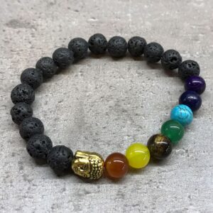 Pulsera elástica de cuentas de lava negra con una cabeza de Buda de tono dorado y cuentas de colores de los chakras