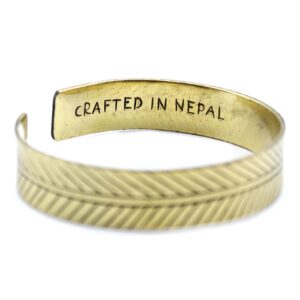 Pulsera abierta de latón con una hoja grabada a lo largo de la banda