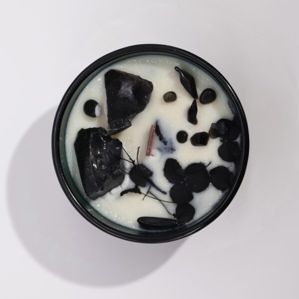 Vela de cera de soja con obsidiana negra y flores secas negras en vaso verde, vista desde arriba