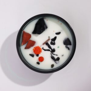 Vela de cera de soja con jaspe rojo, ágata negra y flores secas naranjas, vista desde arriba