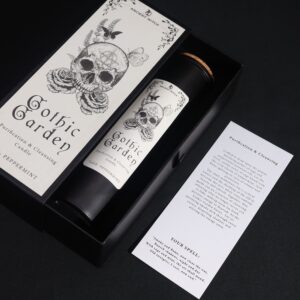 Vela ritual Jardín gótico en vaso negro junto a su caja ilustrada con una calavera entre rosas