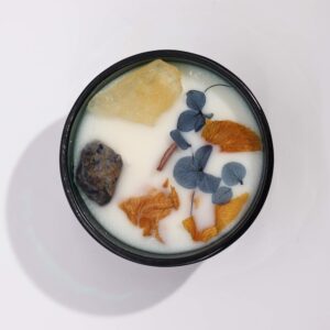 Vela de cera de soja con citrino, sodalita y pétalos secos azules y naranjas, vista desde arriba