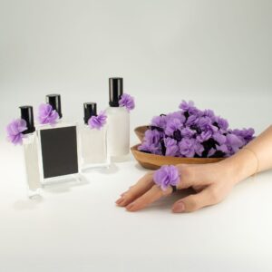 Anillo con flor de gasa color lavanda de varias capas sobre banda elástica negra