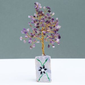 Árbol grande de amatista con copa densa de lascas violetas en ramas doradas sobre una base alta de jaspe con flor negra pintada