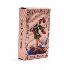 Baraja de tarot en oro rosa: caja con el Loco a color y reverso de carta con un sol de rostro y fases de la luna en rojo cobrizo
