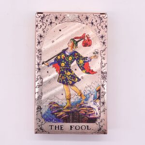 Baraja de tarot en oro rosa: caja con el Loco a color y reverso de carta con un sol de rostro y fases de la luna en rojo cobrizo