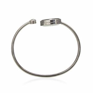 Brazalete abierto de acero con un medallón difusor redondo con una libélula calada sobre fieltro turquesa y un brillante en el otro extremo