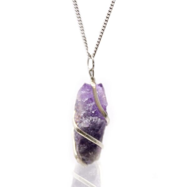 Colgante de amatista en bruto, violeta con zonas más claras, envuelto en una espiral de metal plateado, con cadena