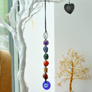 Colgante decorativo de siete piedras de colores en red de cordón negro con un ojo turco azul al final, colgado de una rama blanca