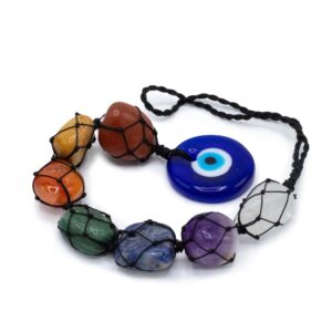 Colgante decorativo de siete piedras de colores en red de cordón negro con un ojo turco azul al final, colgado de una rama blanca