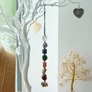 Colgante de siete piedras de los chakras en red de cordón negro con racimo de lascas de colores, colgado de una rama blanca