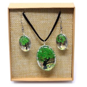 Colgante y pendientes ovalados de vidrio con un árbol de la vida de flores prensadas verdes y cordón negro, en su caja