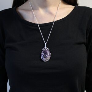 Collar de amatista pulida en óvalo, violeta con la base más clara, envuelta en hilos de alambre plateado, con cadena