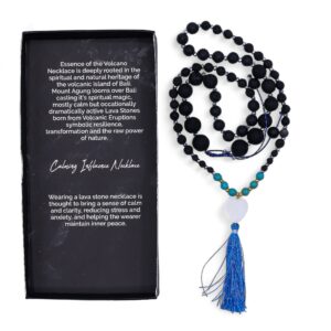 Collar largo de cuentas de piedra de lava con tramo turquesa, corazón blanco y borla azul, junto a su caja negra
