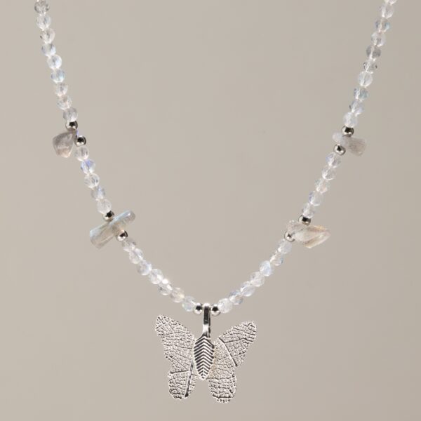 Collar fino de labradorita gris clara con destellos azules y mariposa de hoja natural bañada en plata