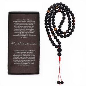 Collar largo de cuentas de piedra de lava negra y ojo de tigre con remate de cordón rojo y dos cuentas colgando, junto a su caja negra