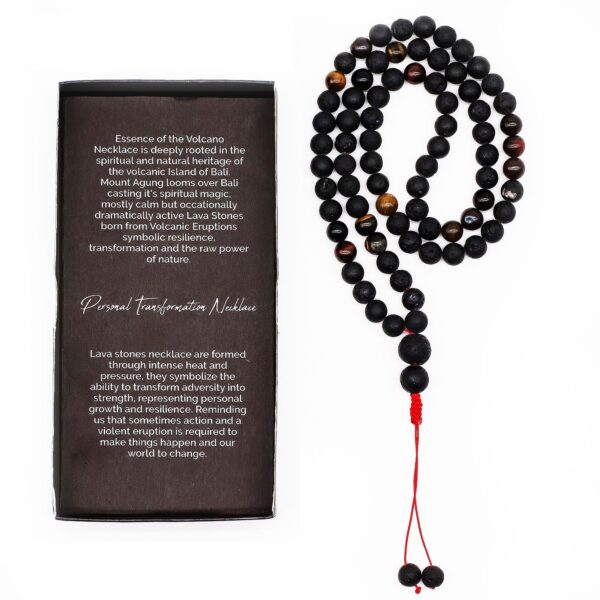 Collar largo de cuentas de piedra de lava negra y ojo de tigre con remate de cordón rojo y dos cuentas colgando, junto a su caja negra