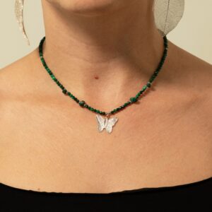 Collar de cuentas facetadas de malaquita verde con lascas pulidas y una mariposa plateada que conserva los nervios de una hoja real