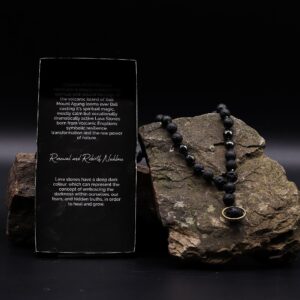 Collar negro de cuentas de piedra de lava y cuentas facetadas con colgante de una cuenta de lava dentro de un aro dorado, junto a su caja
