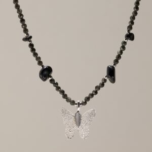 Collar negro de obsidiana facetada y lascas pulidas alrededor de una mariposa con baño de plata y nervadura de hoja