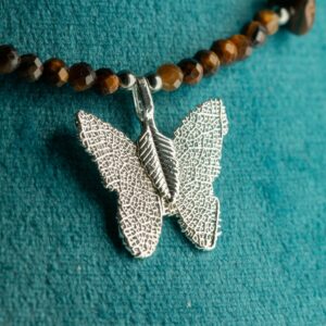 Collar de ojo de tigre marrón dorado facetado, con lascas y una mariposa con nervios de hoja y baño de plata