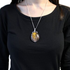 Collar de ojo de tigre pulido en óvalo, marrón y dorado, sujeto con hilos de alambre plateado cruzados en arcos, con cadena