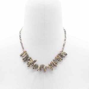 Collar de piedra dálmata color crema con manchas negras, con lascas alargadas en abanico, puesto en un maniquí